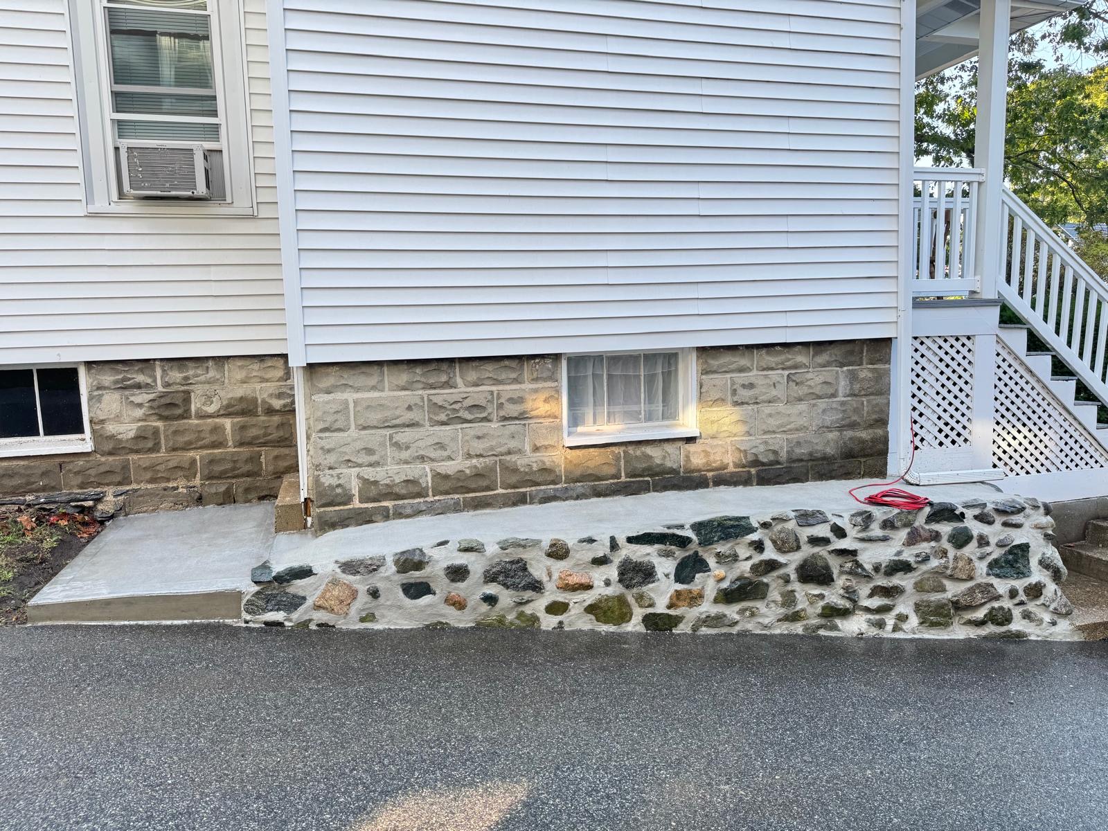 New concrete apron and stone foundation facing